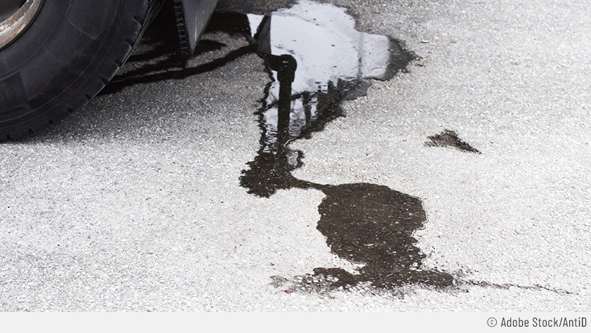 Es sind dunkle Ölflecken neben einem geparkten Auto zu sehen: Das Auto verliert Öl!