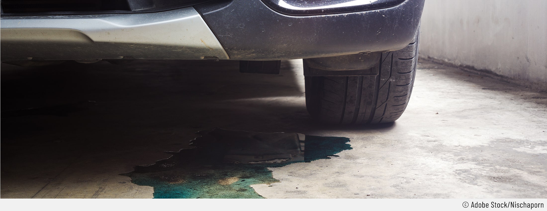 Auf dem Bild ist ein Kühlwasserfleck unter einem Auto zu sehen.