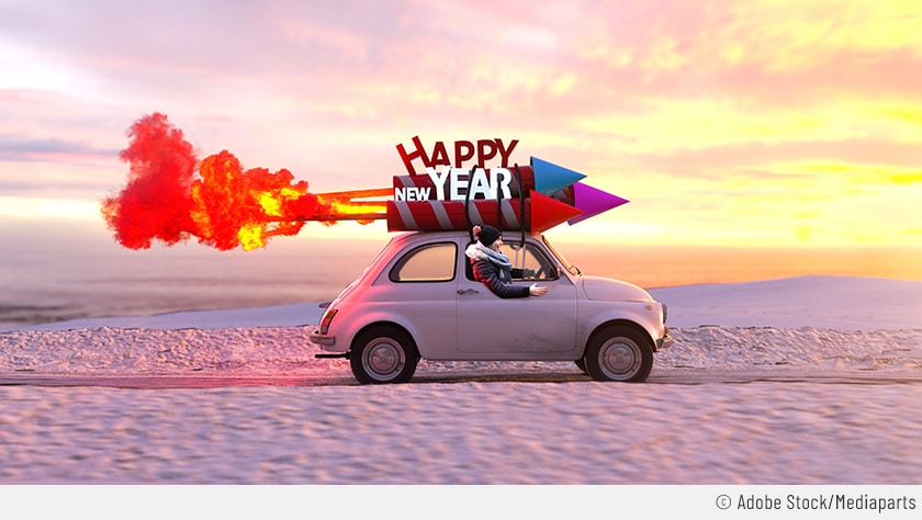 Auf dem Bild ist ein Kleinwagen zu sehen, der durch eine Winterlandschaft fährt. Auf dem Dach sind drei Silvesterraketen festgeschnürt inklusive einem Schriftzug "Happy New Year".