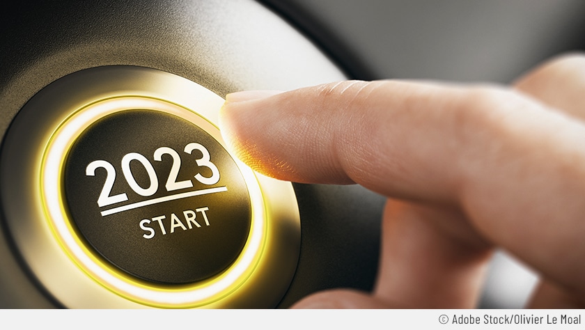 Auf dem Bild sieht man eine Hand, die mit ausgestrecktem Zeigefinger den Start/Stopp-Knopf eines Autos drückt. Auf diesem hier steht allerdings "2023 – Start".