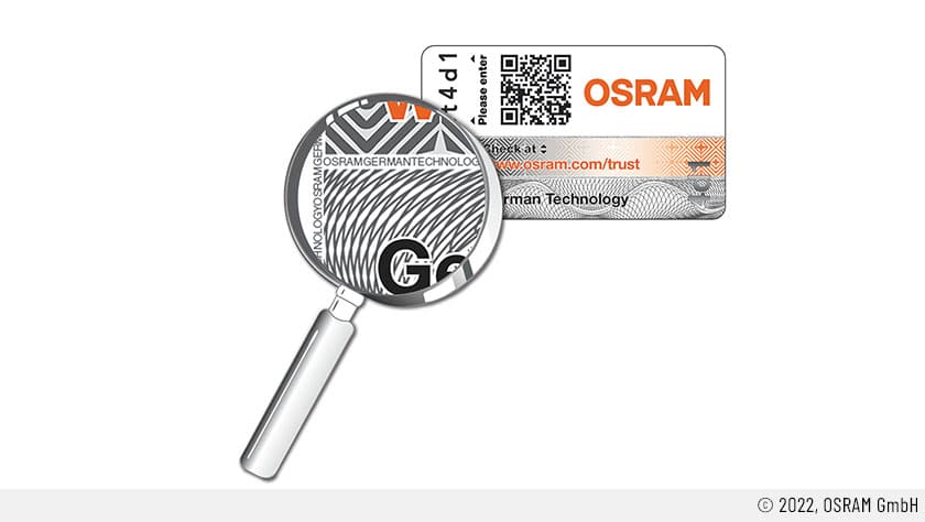 Auf dem Bild ist ein OSRAM-Trust-Sticker zu sehen. Dieser beinhaltet unter anderem die orangefarbene Aufschrift OSRAM, samt URL für die Verifizierung. Es ist auch ein QR-Code zu sehen sowie die Kennziffer, die für die Verifizierung der erworbenen Retrofit-LEDs notwendig ist. Eine Lupe vergrößert die Ansicht.