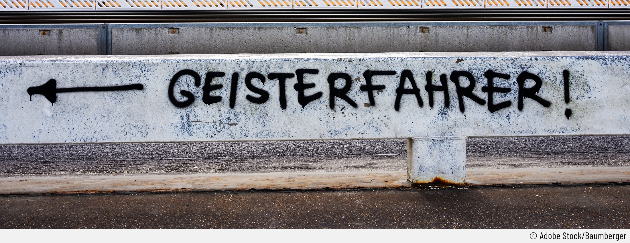 Auf dem Bild sieht man ein Graffti auf einer Leitplanke, das "Geisterfahrer!" sagt, während ein Pfeil nach links zeigt.