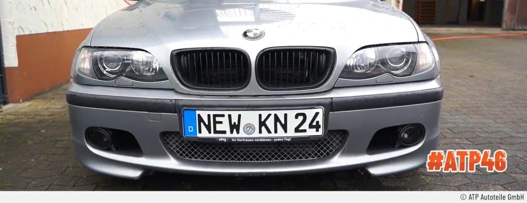 Auf dem Bild ist der silberne BMW E46 von vorne zu sehen - mit Fokus auf die Motorhaube und die das Nummernschild. Die Scheinwerfer sehen nun wie neu aus.