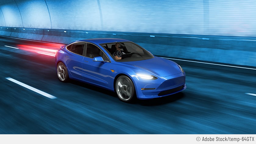Auf dem Bild rast ein blaues Auto durch einen Tunnel. Es könnte ein Tesla außer Kontrolle sein.