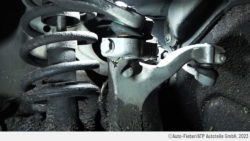 Es ist eine Nahaufnahme der berühmten Audi-Arschlochschraube an der Mehrlenkerachse. Noch ist sie völlig unversehrt und es ist noch offen, ob die Schraube sich einfach herausdrehen lassen wird.