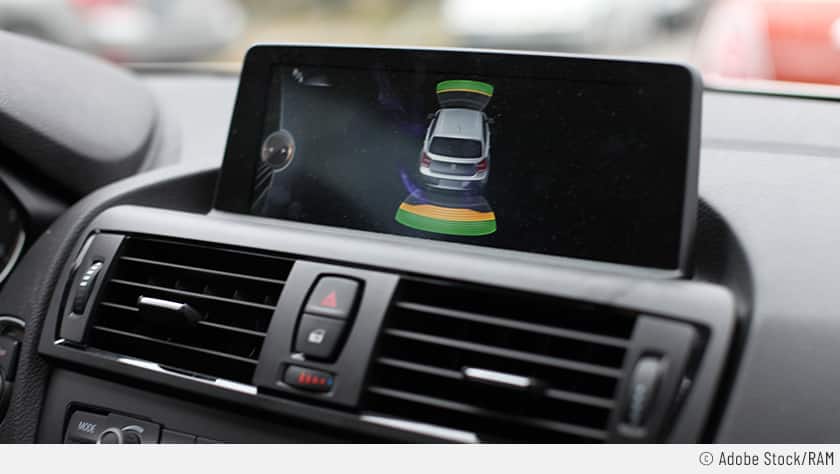 Der Park-Distance-Control-Assistent ist aktiv: Auf dem Display ist ein Auto zu sehen – davor und dahinter zeigen grüne und orangene Markierungen die Nähe zum vorderen bzw. zum hinteren Auto. 