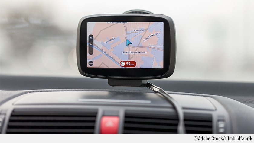 Auf dem Bild ist ein GPS-Navigationsgerät zu sehen, das die Geschwindigkeit viel genauer anzeigt als ein Tacho mit Abweichung. Das Gerät ist auf der Windschutzscheibe eines Autos angebracht.