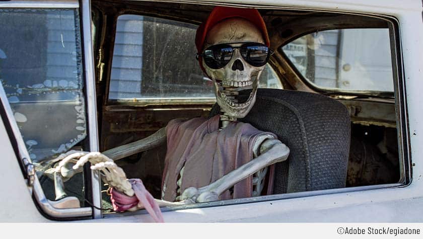 Halloween-Auto mit lachendem Skelett als Fahrer.