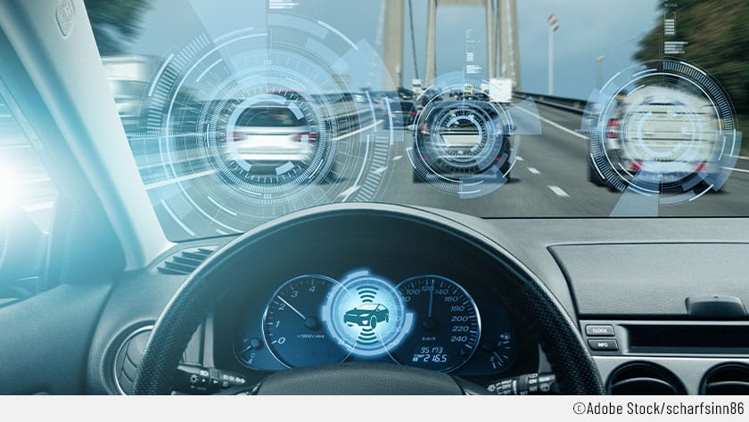 Der Fokus liegt auf dem Kombiinstrument eines vernetzten Autos, das Signale voranfahrender Fahrzeuge empfängt und auswertet.